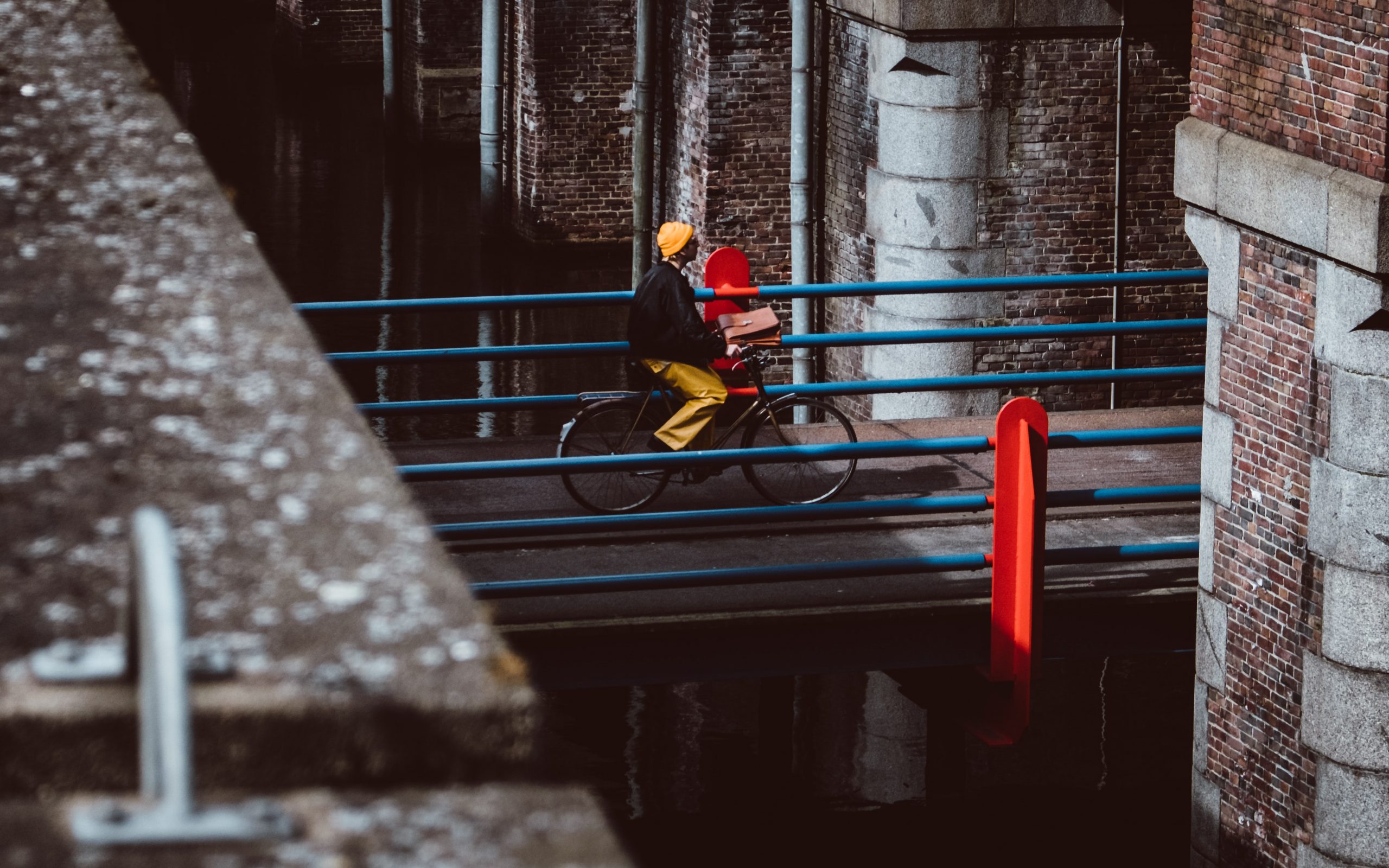 Riding a bike over an urban bridge between buildings