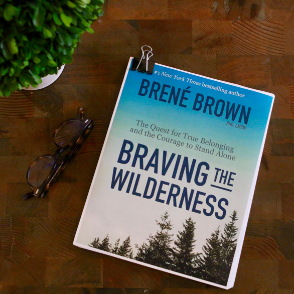 Braving the Wilderness manuscript on a wood table